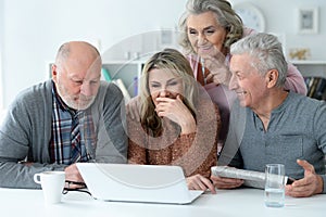Close up portrait of two senior couples sitting at table