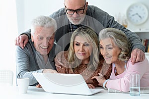 Close up portrait of two senior couples sitting at table