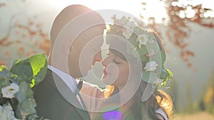 Close-up portrait of wedding couple touching noses outdoors. Close-up of a loving couple of newlyweds with closed eyes