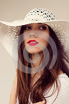 Close-up portrait. White straw hat. Sensual red lips. Boho style