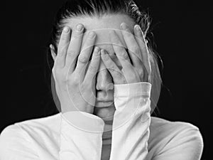 Close up portrait of a woman closing her face by the palms