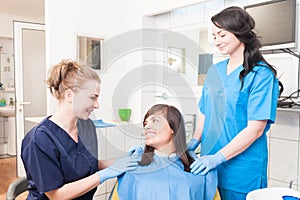 Close-up portrait of woman dentist, her assistant and female pat