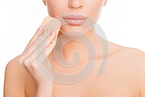 Close up portrait of woman doing maquillage with sponge