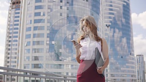 Close-up portrait of a woman in a formal suit. young business woman texting a message on a mobile phone