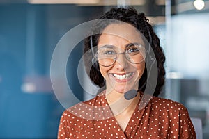 Close-up portrait of a woman with a headset, an online customer support worker smiling and looking at the camera, a