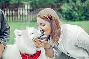 Close-up portrait of woman kissing the face of a dog.