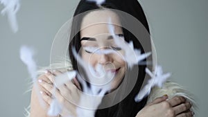 Close up portrait of woman open her eye with feathers falling down makeup