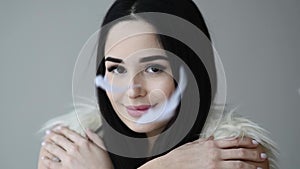 Close up portrait of woman open her eye with feathers falling down makeup