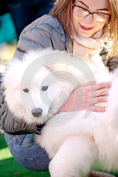 Close up portrait of woman with pet white samoyed, outdoors