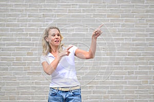 Close up portrait of a woman pointing to the right side and up