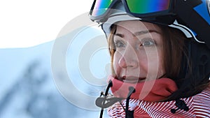 Close up portrait woman skier in the mountains. Skiing or snowboarding. The concept of victory in sports, winning, win