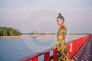 Close up portrait of a woman standing leaning on a wooden bridge