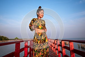 Close up portrait of a woman standing leaning on a wooden bridge