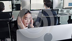 Close Up Portrait of Woman a Technical Customer Support Specialist Talking on a Headset while Working on a Computer in