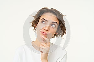 Close up portrait of woman with thoughtful face, thinking of solution, pondering, making choice, standing over white