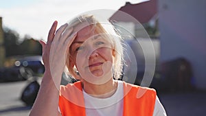 Close up portrait of worker engineer woman with orange vest. Female truck driver