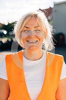 Close up portrait of worker engineer woman with orange vest. Female truck driver