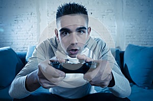 Close up portrait of young addicted man playing video game at night in gaming and addiction concept