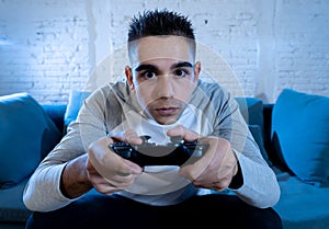 Close up portrait of young addicted man playing video game at night in gaming and addiction concept