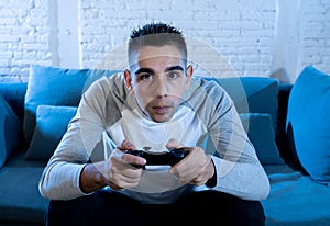 Close up portrait of young addicted man playing video game at night in gaming and addiction concept