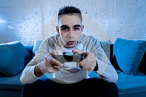 Close up portrait of young addicted man playing video game at night in gaming and addiction concept