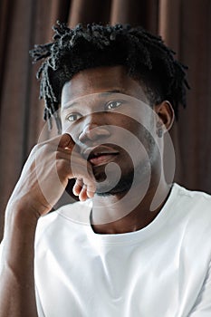 Close-up portrait of young African American man with dreadlocks.