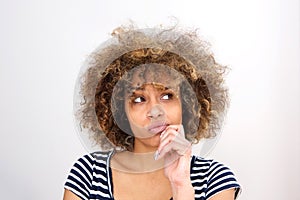 Close up young african woman thinking with hand on chin and and looking away photo