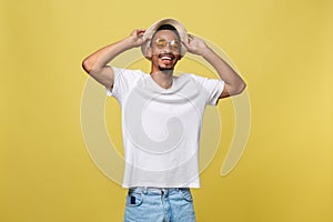 Close up portrait of young afro american shocked tourist , holding his eyewear, wearing tourist outfit, hat, with wide