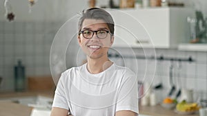 Close up portrait of young asian teenager man looking serious confident at camera in apartment windows background slow