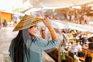 Close up portrait young asian woman with Damnoen Saduak floating market background