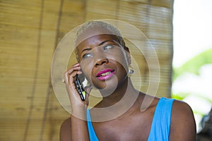 Close up portrait of young attractive and classy black afro american business woman in trendy and stylish hair talking on mobile p