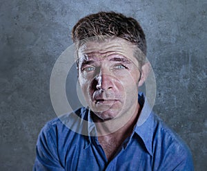 Close up portrait of young attractive man sad and depressed suffering stress and depression feeling lost and desperate in dramatic