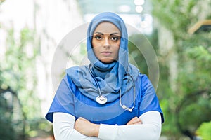 Close-up portrait of young and attractive muslim woman nurse in hijab. Middle Eastern female doctor outdoor on the