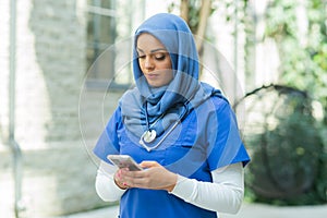 Close-up portrait of young and attractive muslim woman nurse in hijab. Middle Eastern female doctor outdoor on the