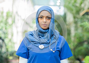 Close-up portrait of young and attractive muslim woman nurse in hijab. Middle Eastern female doctor outdoor on the
