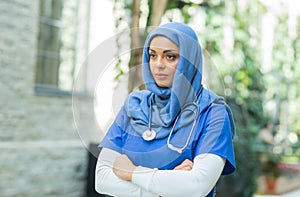 Close-up portrait of young and attractive muslim woman nurse in hijab. Middle Eastern female doctor outdoor on the