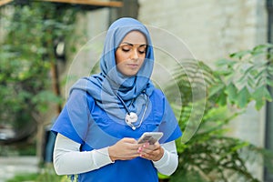 Close-up portrait of young and attractive muslim woman nurse in hijab. Middle Eastern female doctor outdoor on the