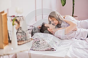 Close up portrait of young attractive romantic couple hugging and kissing, laying down on a bed, being loving with each other.