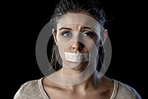 Close up portrait of young attractive woman with mouth and lips sealed in adhesive tape restrained