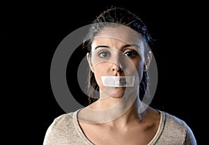 Close up portrait of young attractive woman with mouth and lips sealed in adhesive tape restrained