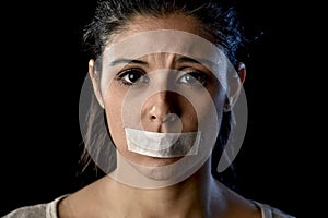 Close up portrait of young attractive woman with mouth and lips sealed in adhesive tape restrained