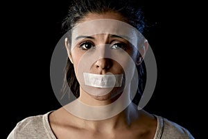 Close up portrait of young attractive woman with mouth and lips sealed in adhesive tape restrained