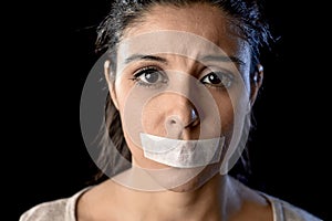 Close up portrait of young attractive woman with mouth and lips sealed in adhesive tape restrained