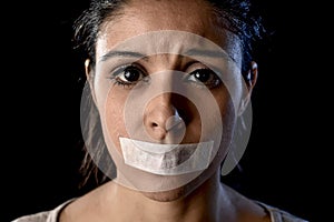 Close up portrait of young attractive woman with mouth and lips sealed in adhesive tape restrained