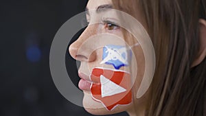 Close-up portrait of young attractive woman with painted social media icons on her face. Addiction to gadgets, web