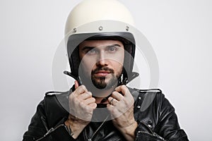 Close-up portrait of young bearded biker man with white cafe-racer helmet. White background.