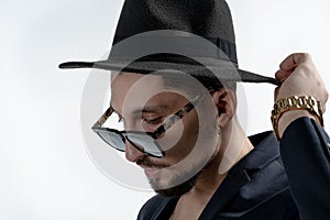 Close up portrait of young bearded serious man in black suit and hat isaolated over white background