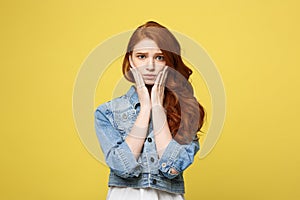 Close up Portrait young beautiful attractive redhair girl worry with something. Golden yellow Background. Copy space.