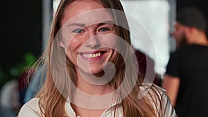 Close-up portrait of young beautiful blonde gen-z boss business woman cheerfully smiling at camera at trendy coworking.