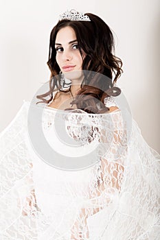 Close-up portrait of young beautiful bride in a wedding dress with a wedding makeup and hairstyle. girl holding white